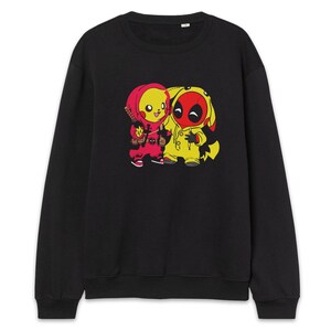 Puede incluir: Sudadera negra con un gr&aacute;fico de dibujos animados de dos personajes. Uno es rojo y amarillo, como Pikachu, y el otro es amarillo y rojo, como Deadpool. Se abrazan. La sudadera est&aacute; hecha de un material suave.