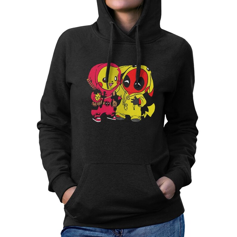 Puede incluir: Sudadera con capucha negra con un gr&aacute;fico de dos personajes de dibujos animados. Uno es rojo y el otro amarillo. La sudadera tiene un bolsillo delantero y una capucha con cord&oacute;n. Los personajes est&aacute;n uno al lado del otro.