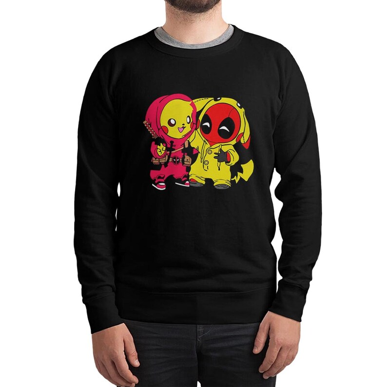 Puede incluir: Sudadera negra con un gr&aacute;fico de dos personajes de dibujos animados. Uno es amarillo y rojo, como Pikachu, y el otro es amarillo y rojo, como Deadpool. La sudadera tiene cuello redondo y mangas largas.