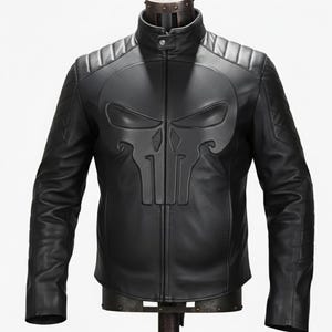 May include: Black leather jacket with a skull emblem on the chest. The jacket has a stand-up collar, quilted shoulder detailing, and a front zip. The long sleeves and the jacket are displayed on a mannequin.