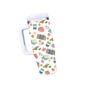 Product example of 40 oz tumbler with cozy fall seamless design with pumpkins, coffee cups, spilled coffee, books, and fall leaves.