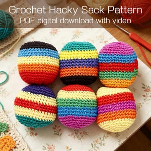 May include: Six colorful, crocheted hacky sacks in a variety of rainbow color combinations. The image includes the text "Crochet Hacky Sack Pattern PDF digital download with video". The hacky sacks are arranged on a floral patterned surface.