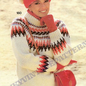 May include: A white knitted sweater with a colorful geometric pattern, worn with a red hat and matching gloves. The sweater has a high neck and long sleeves. The model is also wearing a red bag.