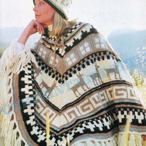 Puede incluir: Un poncho de punto con un patrón geométrico en tonos marrones, blancos, negros y azules. El poncho tiene un borde de flecos y presenta un diseño de animales estilizados. También se incluye un gorro de punto a juego.