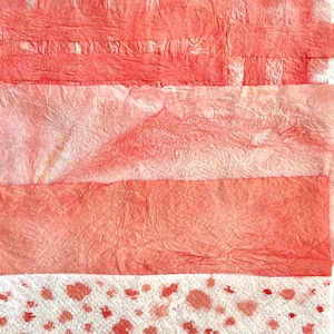May include: Abstract composition featuring layers of textured, red-toned paper and white paper with red spots. The arrangement includes horizontal bands of varying shades of red, creating a visual contrast and depth. The overall aesthetic is artistic and tactile.