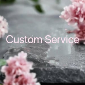 May include: The image features the text "Custom Service" in a soft pink hue, set against a blurred background of pink flowers and a textured, gray surface. The overall aesthetic is soft and inviting.