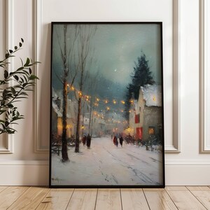 Pode incluir: Pintura emoldurada de uma paisagem de inverno. A cena retrata uma rua coberta de neve com edifícios e árvores. Luzes quentes iluminam a rua e figuras caminham ao longe, criando um ambiente acolhedor.