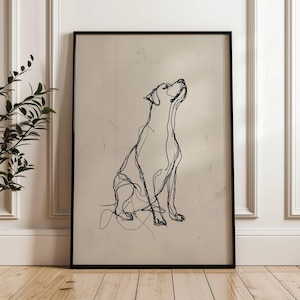 May include: Black framed art print featuring a minimalist line drawing of a dog looking upwards. The artwork is a continuous line illustration on a neutral background, creating a modern and elegant aesthetic. The dog is depicted in a seated position.