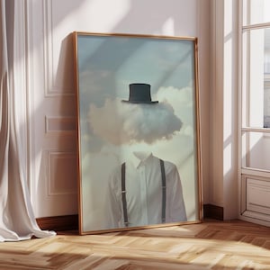 Puede incluir: Una impresión enmarcada de una imagen surrealista que presenta a una persona con una nube como cabeza que lleva un sombrero de copa negro. El fondo es un cielo azul claro con nubes blancas.