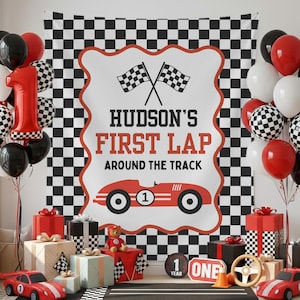 May include: A festive first birthday party scene with a checkered backdrop and balloons in red, black, white, and checkered patterns. The banner reads "Hudson's First Lap Around the Track" with a red race car illustration. Gifts and toy race cars complete the decor.