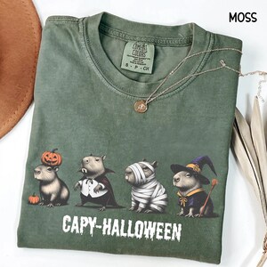 Celebrate spooky season in style with this Halloween Capybara Social Club shirt — perfect for anyone who loves retro vibes, chill capybara energy, and a touch of festive flair! Printed on ultra-soft Comfort Colors®, this Halloween t-shirt is a must-have for fall. Whether you’re rocking a spooky and cute look, a pumpkin capybara tee, or a playful ghost capybara vibe, this design blends cozy comfort with trendy social club style for the ultimate autumn statement.