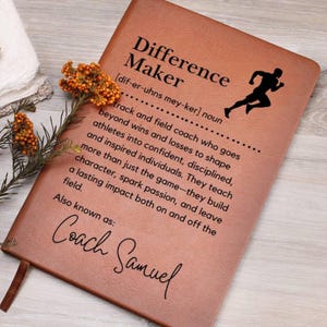 May include: A brown leather journal with the words "Difference Maker" and a definition of the word. The journal also has a running figure and the signature "Coach Samuel".