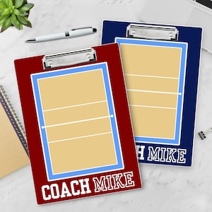 May include: Two volleyball coach clipboards. One is burgundy with a light blue border and the text "COACH MIKE" in white. The other is navy blue with a light blue border and the text "MIKE" in white. Both have a volleyball court diagram.