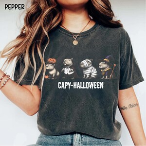 Celebrate spooky season in style with this Halloween Capybara Social Club shirt — perfect for anyone who loves retro vibes, chill capybara energy, and a touch of festive flair! Printed on ultra-soft Comfort Colors®, this Halloween t-shirt is a must-have for fall. Whether you’re rocking a spooky and cute look, a pumpkin capybara tee, or a playful ghost capybara vibe, this design blends cozy comfort with trendy social club style for the ultimate autumn statement.