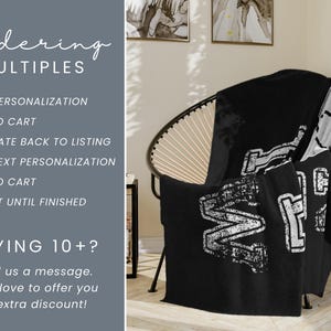 May include: A black blanket with a white distressed graphic is draped over a black chair. The blanket has the word "MF" in large letters. Text on the left side of the image reads "Ordering MULTIPLES".