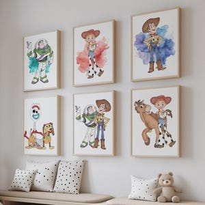 May include: A set of framed watercolour prints depicting characters from the animated film Toy Story. The artwork includes images of Woody, Buzz Lightyear, Jessie, and other characters, with a neutral colour palette.