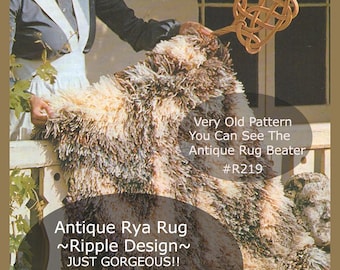 May include: A close-up of a brown and white rug with a ripple design. The rug is being held up by a person's hand. The text on the image reads "Antique Rya Rug ~Ripple Design~ JUST GORGEOUS!! Latch Hook Graphs Not A Rug Very Old Pattern You Can See The Antique Rug Beater #R219"