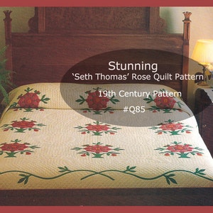 Peut inclure: Une couette blanche avec un motif de roses rouges sur un lit avec une tête de lit en bois. Le motif de la couette est appelé 'Seth Thomas' Rose Quilt Pattern' et est un motif du 19ème siècle. Le numéro du motif est #Q85.