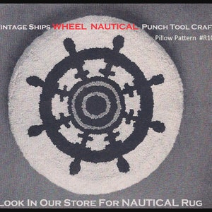 May include: Circular, cream-coloured cushion featuring a navy blue ship's wheel design. The nautical-themed punch tool craft has text that reads "Vintage Ships Wheel Nautical" and "Pillow Pattern #R10".