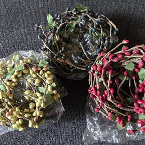 Puede incluir: Tres rollos de guirnalda de bayas, uno con bayas rojas, uno con bayas verdes y uno con bayas negras.
