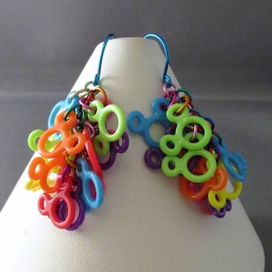 Puede incluir: Un par de pendientes colgantes con un grupo de abalorios de pl&aacute;stico de colores en forma de cabezas de Mickey Mouse. Los abalorios son en tonos de verde, naranja, amarillo, rojo, morado y azul.