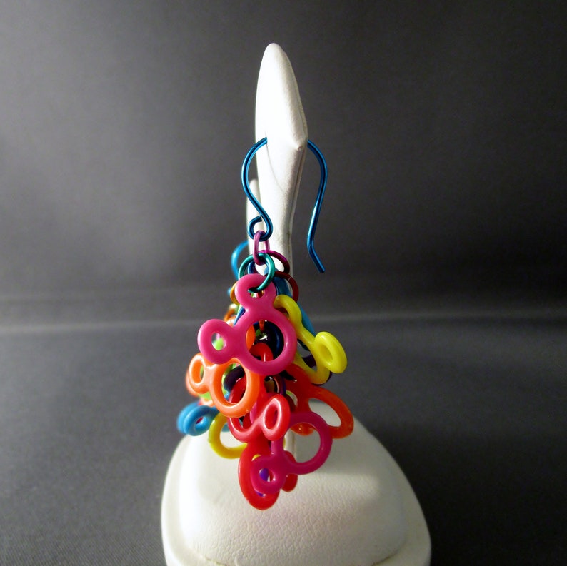 Puede incluir: Encantos de pl&aacute;stico con forma de Mickey Mouse de colores arco&iacute;ris cuelgan de un gancho de arete de alambre azul.