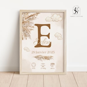 Peut inclure: Une affiche encadrée sur fond beige avec une grande lettre marron "E" et le nom "Eden" en dessous. L'affiche comprend la date "29 Janvier 2025" et des icônes liées à bébé avec des mesures. Des nuages et des herbes de la pampa décorent l'affiche.