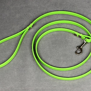 May include: A bright green dog leash with a silver clip. The leash is made of a durable, flexible material.