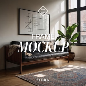 May include: A black framed poster mockup with the text "YOUR DESIGN HERE" in a living room setting. The poster is hanging above a brown leather sofa with a throw blanket and pillows. A potted plant is in the corner of the room, and a rug is on the floor.
