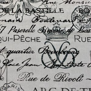 May include: A beige fabric with black text and images. The text includes French words and phrases such as "Rue de Rivoli", "Arc de Triomphe", "Place Jean", and "Qui-Pêche".