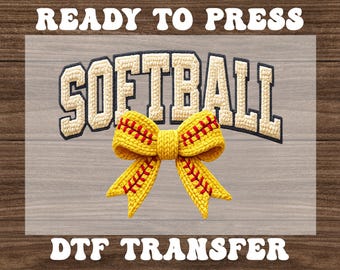 May include: A yellow softball bow with red stitching is centered below the word "SOFTBALL" in a cream-colored, textured font. The words "READY TO PRESS" and "DTF TRANSFER" are above and below the design, respectively.