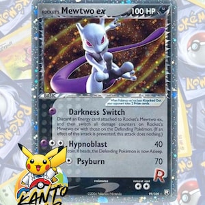 Puede incluir: Carta coleccionable Pokémon holográfica con Mewtwo ex. La tarjeta tiene un borde plateado y una ilustración de Mewtwo morado y blanco. El texto incluye "Darkness Switch" e "Hypnoblast". El logotipo de Kanto Lab es visible.