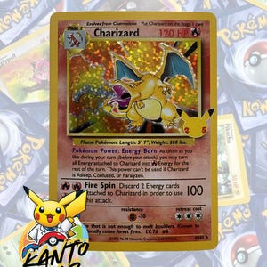 May include: A holographic Charizard Pokémon card. The card features a yellow and orange Charizard illustration with blue wings. The card text includes "Charizard", "120 HP", and "Fire Spin". The card is from the 4/102 set.