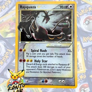 May include: A Rayquaza Pokémon trading card with a yellow border. The card features a black and gray illustration of Rayquaza, a serpentine dragon-like creature. The card text includes "Spiral Rush" and "Holy Star" attack descriptions. The card is labeled "107/107".