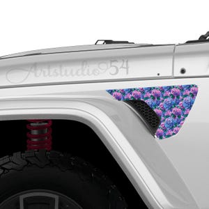 May include: A white vehicle with a floral design on the side panel. The design features blue, purple, and pink hydrangea flowers. The text "Artstudio 54" is visible on the vehicle's body.
