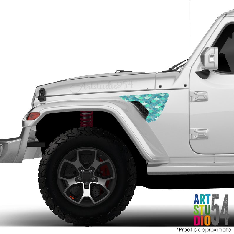 May include: A white Jeep with a teal and blue mermaid scale design on the front fender. The text "Artstudio54" is written on the hood. The vehicle has black tires and red suspension springs.
