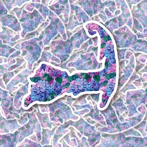 May include: A sticker of the outline of Cape Cod, Massachusetts, filled with a pattern of purple and pink hydrangeas. The sticker is surrounded by other Cape Cod stickers.