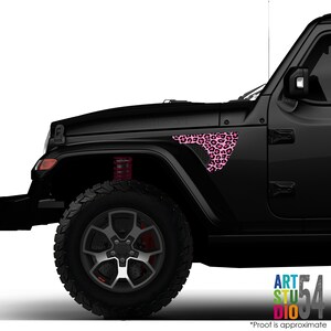 May include: Black Jeep with a pink leopard print design on the front fender. The design is a triangular shape with a honeycomb mesh pattern. The text "ART STUDIO 54" is visible in the bottom right corner.
