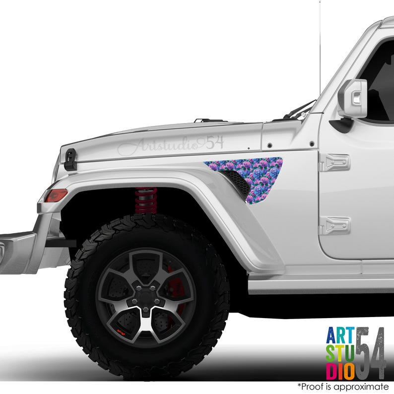 May include: A white Jeep with a floral decal on the front fender. The decal features a pattern of blue and purple flowers. The text "Artstudio 54" is above the fender. The tire is black with a silver rim.