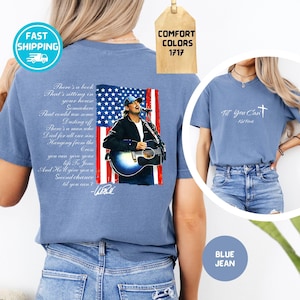 May include: A blue jean-colored t-shirt featuring a graphic of a singer with an American flag background, a guitar, and the text "There's a book...til you can't." A second shirt shows the text "Til You Can't - Kid Rock."