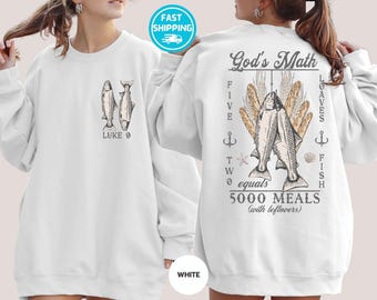 Peut inclure: Sweat-shirt blanc avec un motif de deux poissons et le texte "LUKE 9" sur le devant. Le dos présente le texte "God's Math" avec des illustrations de poissons, de pain et le texte "5000 MEALS (with leftovers)".