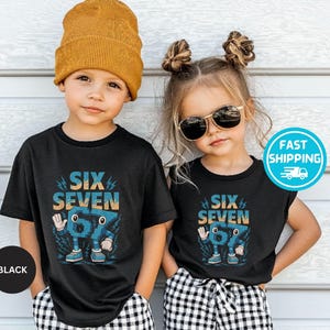 May include: Two children wearing black t-shirts with the text "SIX SEVEN" in blue and orange. The graphic features a cartoon number 67 character. One child wears a mustard yellow beanie, the other wears sunglasses. Both are wearing black and white checkered pants.