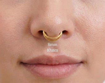 Puede incluir: Un anillo de septum dorado con un diseño de aro de doble capa. La joya está colocada en la nariz, con el texto 8mm y 10mm mostrado debajo del aro para indicar las dos opciones de tamaño disponibles para esta pieza circular.
