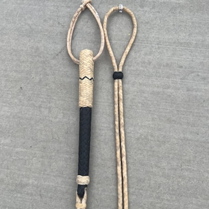May include: Two braided leather reins with a black leather handle. The reins are made of natural colored leather and have a loop at the end.