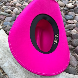 Puede incluir: Un sombrero de vaquero fucsia vibrante. El sombrero tiene un forro interior negro y una banda negra alrededor del borde interior. El sombrero est&aacute; hecho en M&eacute;xico y es talla L.