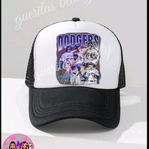 May include: A black and white trucker hat with a curved brim. The front panel is white and features a graphic of the Los Angeles Dodgers baseball team with the word "Dodgers" in blue. The hat has a mesh back.