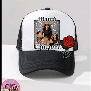 May include: A black and white trucker hat with a graphic of a woman and three children, with the words "Mamá Chingona" in black script. A red rose is on the right side of the hat. The hat has a black brim and mesh back.