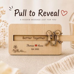 May include: A wooden plaque with the text "Pull to Reveal" and "Better Together." It features stick figure illustrations and the names "Thomas" and "Anna" with a heart symbol, and the year "Est. 2021."