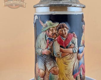 Stary niemiecki kufel do piwa: ręcznie malowana bawarska scena ludowa, cynowa pokrywka