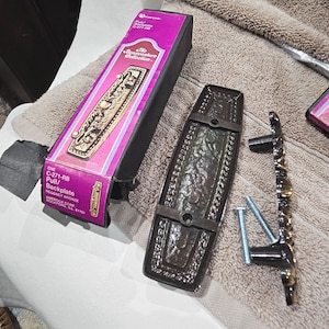 May include: A white ceramic mug with a black handle and the text "But First, Coffee" in a black, handwritten-style font. The mug is on a white surface.